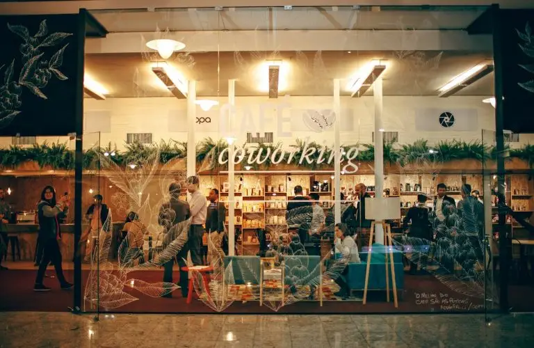 A cozy and bustling indoor coworking space with people engaged in work and conversation.